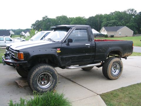 1986 Ford F-150 - This lifted pickup truck has a custom front bumper and side steps.
