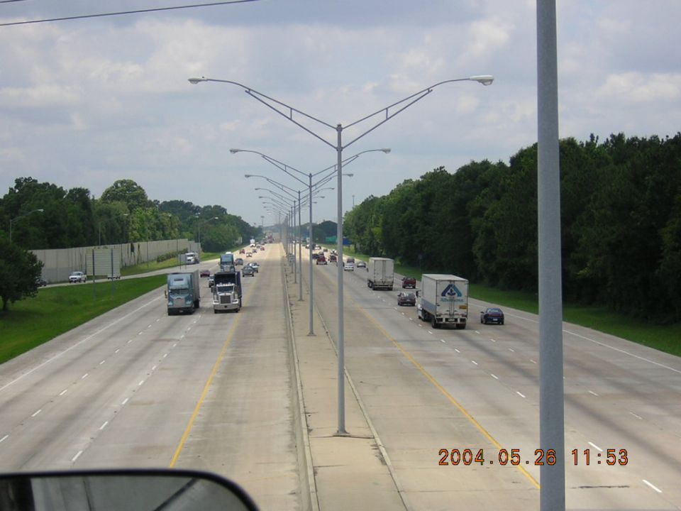 Highway with multiple trucks and cars. Taken from a vehicle
