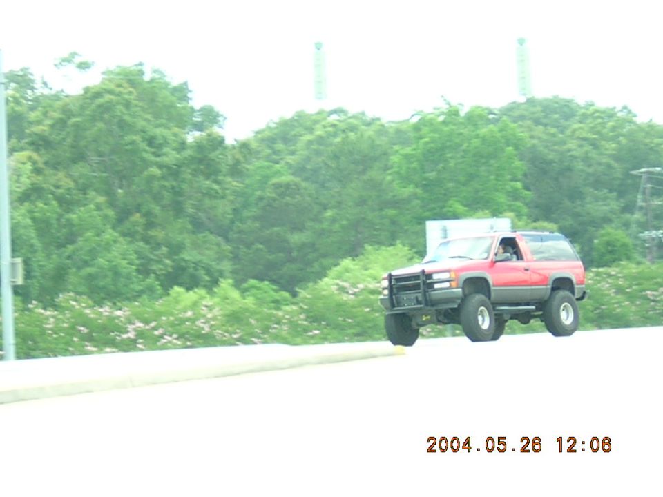Red SUV with off-road tires, 3/4 front view. Appears to be a 1995 model