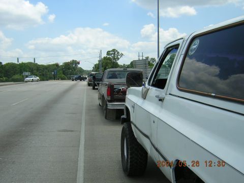 1984 Chevrolet Blazer - Several trucks are lined up on a highway under a cloudy sky. The foreground vehicle is white.