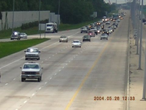 1984 Chevrolet Blazer - A procession of vehicles travels down a multi-lane highway.