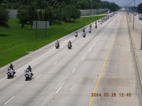 1984 Chevrolet Blazer - A large group of motorcycles rides down a highway, led by police motorcycles.