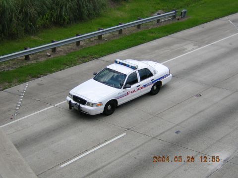1984 Chevrolet Blazer - White police car with light bar driving on a highway.