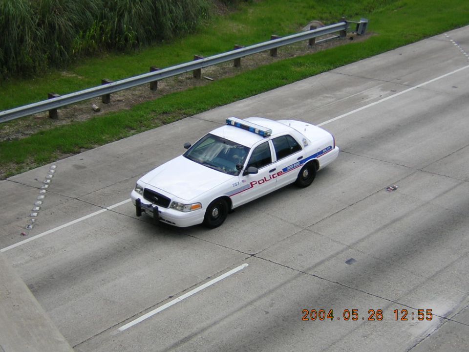 White Ford Crown Victoria police cruiser unit 751 on a highway shoulder, shot from above