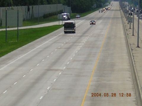 1984 Chevrolet Blazer - A highway scene shows a bus in the left lane, a truck on the shoulder, and several cars in the distance.