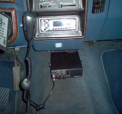 1988 Ford Bronco - The interior of a vehicle features a CB radio and microphone, with a gear shift visible.