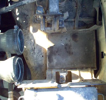 1988 Ford Bronco - Close-up view of engine bay components, including hoses and metal structures.