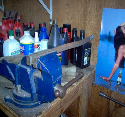 1988 Ford Bronco - Workbench setup with tools, fluids, and a decorative poster.