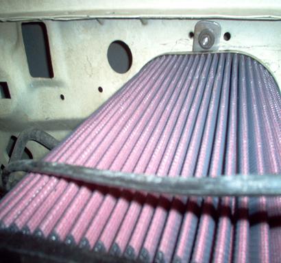 1988 Ford Bronco - Close-up view of a pink pleated engine air filter with a metal bracket above it.