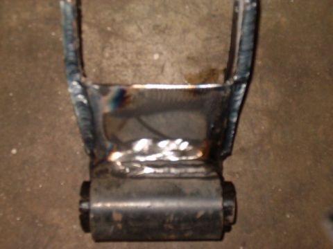 1988 Ford Bronco - A close-up view of a welded metal bracket with a rubber bushing, likely a suspension component.