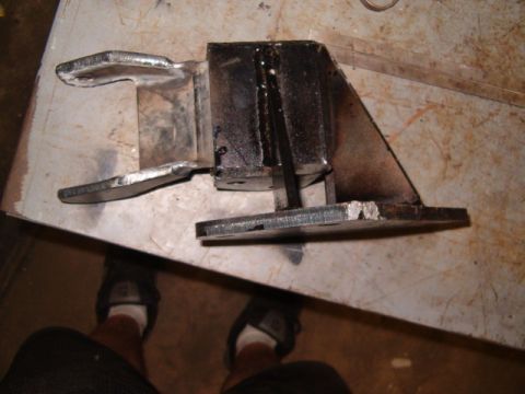 1988 Ford Bronco - A close-up view of a welded metal component, possibly a vehicle part, resting on a surface.