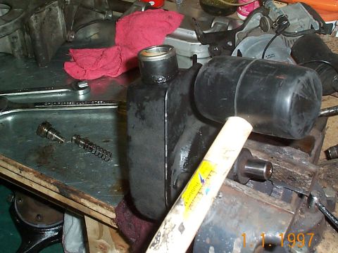 1992 Ford Bronco - With the bolts removed from the resevoir and the unit in the vise, take a soft rubber mallet and hit the resevoir. The can should come righ…