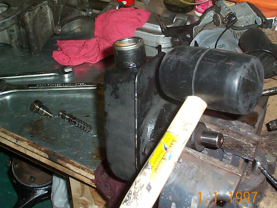 With the bolts removed from the resevoir and the unit in the vise, take a soft rubber mallet and hit the resevoir. The can should come right off.