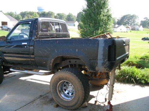 1986 Ford F-150 - This pickup truck is missing its tailgate and rear bumper, with its rear end elevated on blocks.