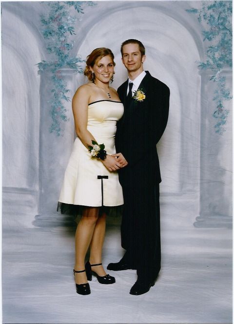 2000 Jeep Liberty - A couple dressed in formal attire poses for a photograph in front of a painted backdrop.
