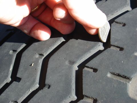 1991 Ford Bronco - Checking tire tread depth with a coin.
