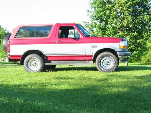 1995 Ford Bronco - This two-tone Ford Bronco is shown from the side, parked on a grassy lawn.