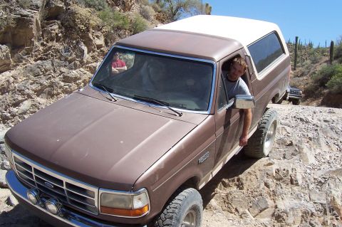 1992 Ford Bronco - This Ford Bronco navigates a challenging rocky terrain, with another vehicle following closely behind on the trail.