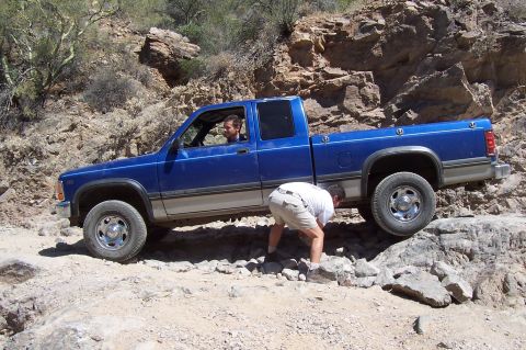 1992 Ford Bronco - A blue Dodge Dakota pickup truck is shown off-roading on a rocky trail.