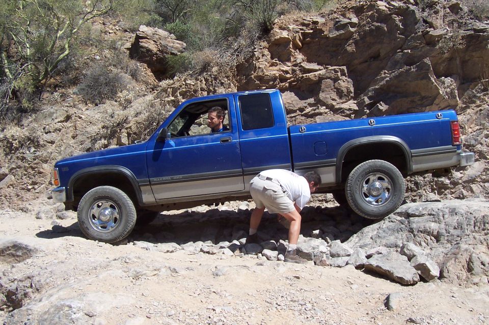 Blue Dodge Dakota pickup truck navigating rocky terrain off-road