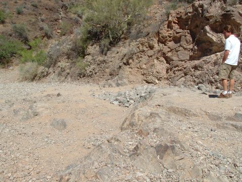 1990 Ford Bronco - A man stands in a rocky desert landscape, observing the terrain.