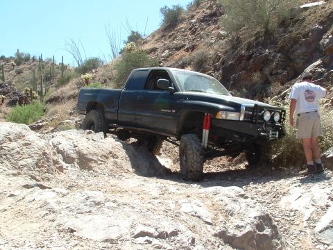 1990 Ford Bronco - A modified pickup truck tackles a challenging off-road course in a desert environment.