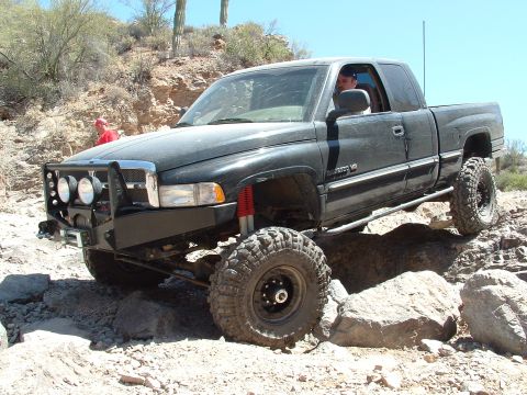 1990 Ford Bronco - This modified pickup truck tackles a challenging off-road course with large tires and a custom bumper.