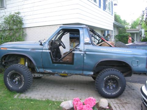 1986 Ford Bronco - This modified Ford Bronco features half doors and a roll cage, with a visible website address on its side.
