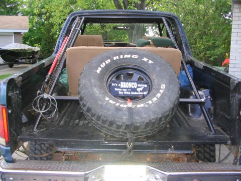 1986 Ford Bronco - The spare tire in the rear of the vehicle has a "Bronco thing" plate and "Mud King XT" branding.
