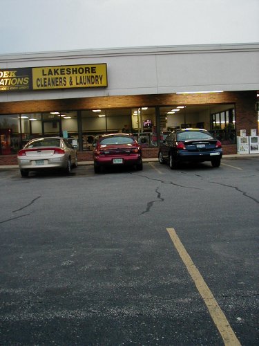 1997 Ford Taurus - Three sedans are parked in front of a commercial building with a sign for Lakeshore Cleaners & Laundry.