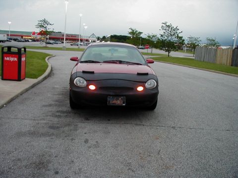 1997 Ford Taurus - A red 1997 Ford Taurus is parked in front of a Meijer store.