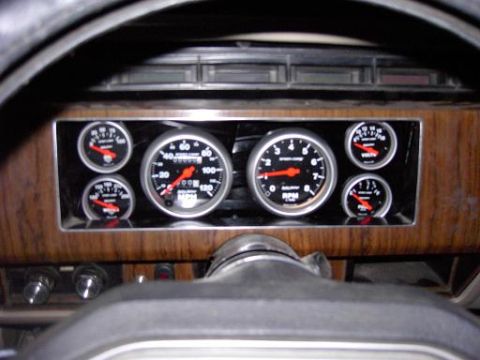 1980 Ford Bronco - Aftermarket gauges installed in a vehicle's dashboard, showing speedometer, tachometer, and other readings.