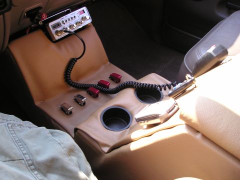 1996 Ford Bronco - Interior view of a custom center console with added electronics and cup holders.