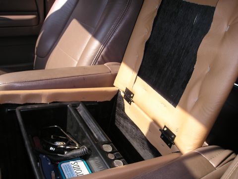 1996 Ford Bronco - Interior view of an open vehicle center console storage compartment.