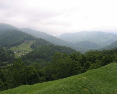 1995 Ford Bronco - A scenic view of rolling green mountains and a valley dotted with houses, under an overcast sky.