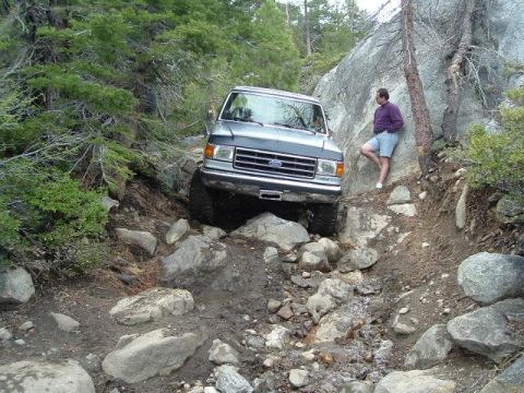1989 Ford Bronco - This 1989 Ford Bronco is tackling a challenging rocky path, with a bystander observing the action.