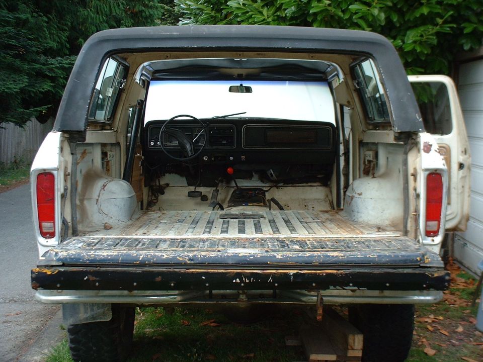 1978 Ford Bronco interior and cargo area, viewed from rear with tailgate down. Dashboard and steering wheel visible