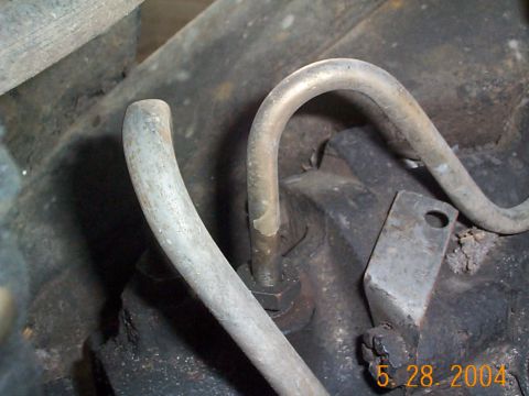 1992 Ford Bronco - Close-up view of metal lines connected to a power steering pump assembly.