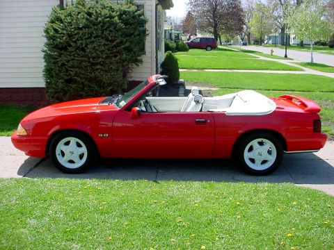 1973 Ford Ranchero - This red convertible sports car has a white interior and white wheels.