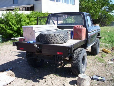 1978 Ford Bronco - This flatbed pickup truck is equipped with off-road tires and a utility bed.