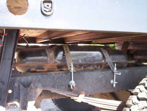1978 Ford Bronco - Close-up view of an aftermarket fuel tank mounted beneath a vehicle's chassis.