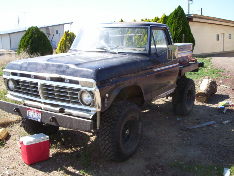 1975 Ford F-Series pickup truck with flatbed, lifted suspension, and off-road tires
