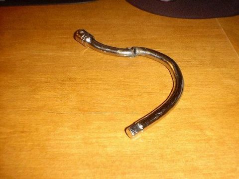1990 Ford Bronco - A chrome-plated metal tool with a bent shaft and a hexagonal socket is shown on a wooden surface.