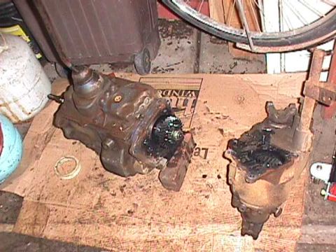 1984 Jeep Wrangler - Disassembled transmission and transfer case parts are laid out on cardboard.