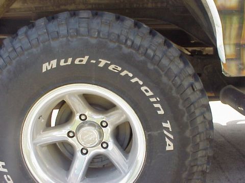 1989 Ford Bronco - Close-up of a tire and wheel, with "Mud-Terrain T/A" visible on the tire sidewall.