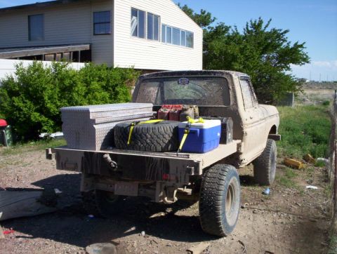 1978 Ford Bronco - This flatbed truck, possibly from the late 1970s, is equipped for work with a large toolbox and spare tire in the bed.