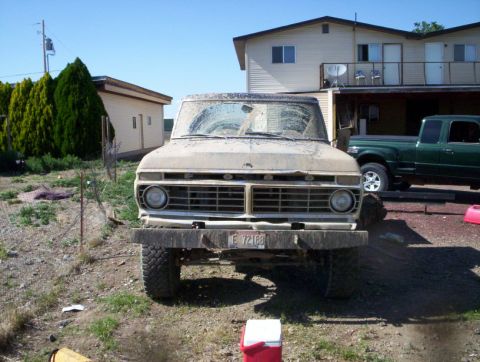 1978 Ford Bronco - This weathered Ford F-Series truck, likely from the early to mid-1970s, sits in a yard with another vehicle visible.
