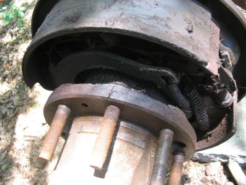 1986 Ford Bronco - Worn brake drum and hub assembly with exposed brake shoes and springs.