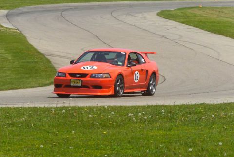 2000 Ford Mustang - Orange 2000 Ford Mustang on a race track with racing numbers 02.