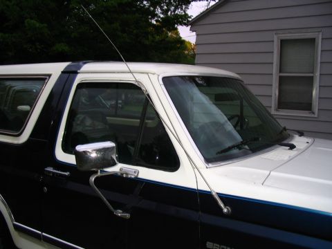 1984 Ford Bronco - This 1984 Ford Bronco features a two-tone paint scheme and is captured from the driver's side 3/4 front perspective.